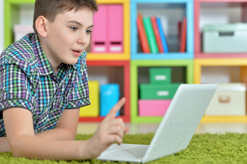 Cute boy using laptop in room