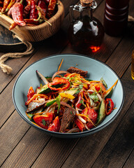 Chinese warm beef salad with vegetables and sesame seeds