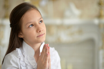 Fototapeta na wymiar Little girl in white blouse praying