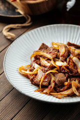 Asian spicy roast meat with onion on the wooden rustic background