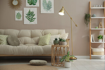 Stylish living room interior with comfortable sofa and beautiful pictures on wall