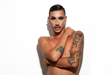 beautiful young drag queen with short hair and mustache with makeup looking at the camera with white background