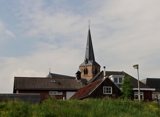 Fototapeta na wymiar Church Oude Kerk above the dike at Nieuwerkerk aan den IJssel