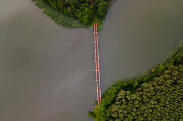 Iron steel frame construction of narrow gauge railway bridge across the river or lake. Bridge with...