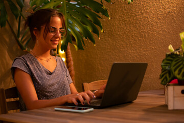 Caucasian teen girl smiling and typing on her laptop.