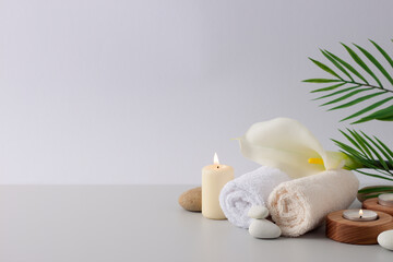 Fototapeta na wymiar Spa treatment with candles, towel and flowers on white background. Close up, copy space