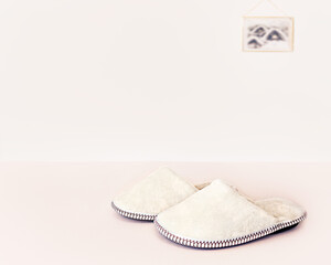 Natural woolen slippers are on the floor. Cozy warm background.