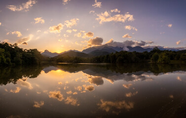 Beautiful sunset view to rainforest lake and reflections on water