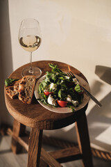 Mozzarella, tomato and basil salad and glass of wine