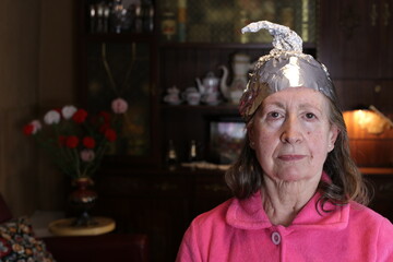 Senior conspiracy theorist wearing weird hat