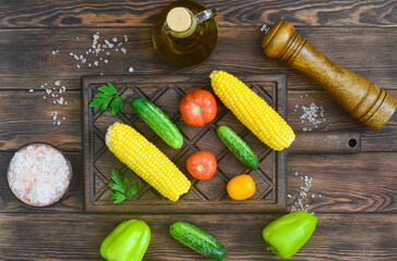 Obraz na płótnie Canvas food background and ingredients for cooking summer salad, pink salt mineral, tomato, cucumber, mill pepper, corn, fresh vegetable on wooden table, vitamin for eating