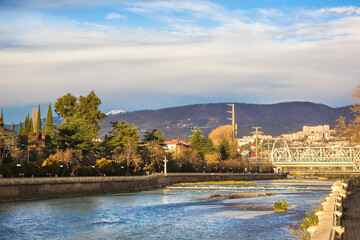 Great park view of the city with snow mountains. Editorial image