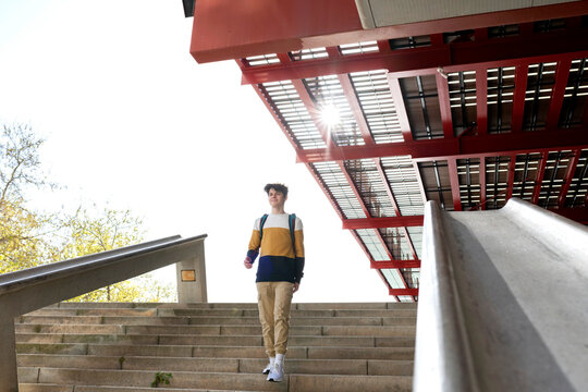 Student with backpack going down stairs outdoor