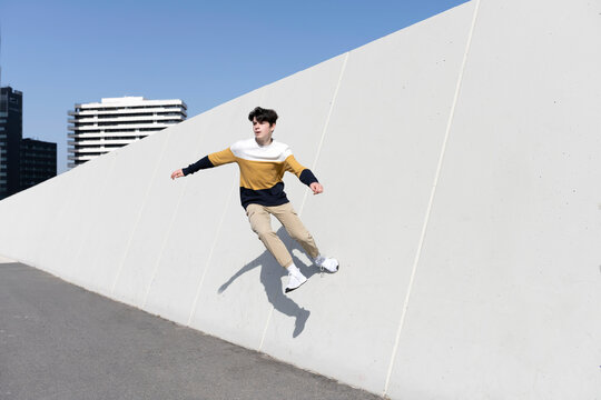 Young man jumping on the urban wall background