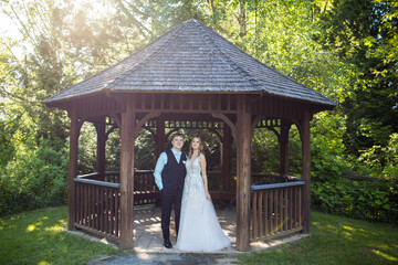 Couple standing, looking ahead under wooden gazebo