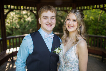 Portrait of happy couple in formal clothing under gazebo.