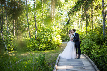 Young romantic couple kiss in forest setting.