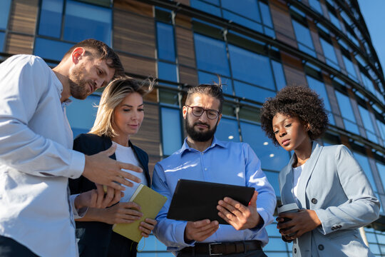 Diverse businesspeople using tablet on street
