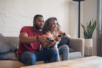 Young couple palying video games together at home. © Mego-studio