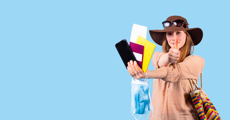 The photo of satisfied woman in comfortable clothes, summer hat and sunglasses having all required document for the trip in pandemic time.