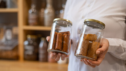 A woman holds a jar with Sweet pureed fruit pastila. Natural weight sweets in an eco store