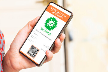 hand woman holding a mobile phone with digital vaccination certificate to certify that have been vaccinated of coronavirus covid-19
