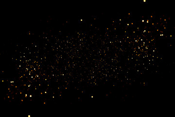 Golden abstract bokeh on black background.