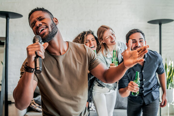 Group of friends playing karaoke at home. - obrazy, fototapety, plakaty