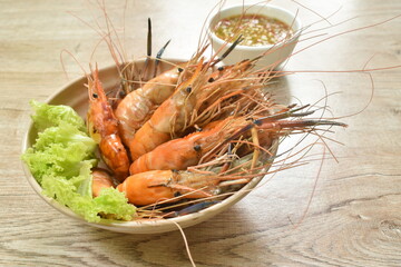 grilled river shrimp arranging with fresh lettuce on bowl dipping spicy sauce