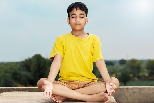A young indian cute kid doing yoga in mediation pose
