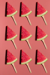 Obraz na płótnie Canvas Colorful fruit pattern of fresh watermelon slices on a pink background.