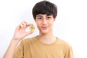 Teenage boy holds a bitcoin on a white isolated background.