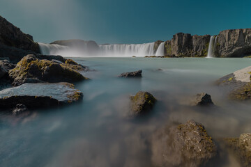 Long exposure photo of magnificent Godafoss waterfall in northern Iceland on a warm summer day. Visible flow of water coming from the waterfall.