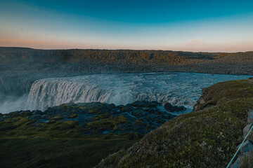 Beautiful Hafragilfoss waterfall in the Dettiffos area, large amount of water falling down making a droplet curtain during summer sunset in rich colors. Nice evening next to a big waterfall.