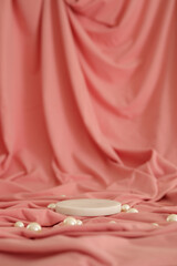 White marble podium on the pink background with pearls. Podium for product, cosmetic presentation. Creative mock up. Pedestal or platform for beauty products.