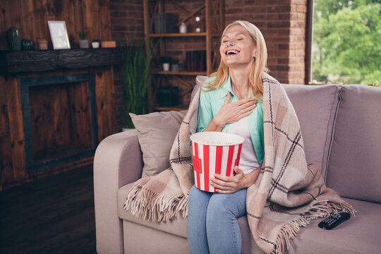 Portrait photo woman watching comedy movie at home eating pop corn laughing spanding free time