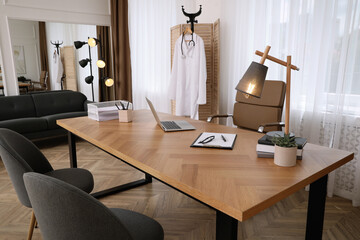 Modern medical office interior with doctor's workplace and chairs