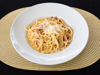 spaghetti alla carbonara in white plate on table