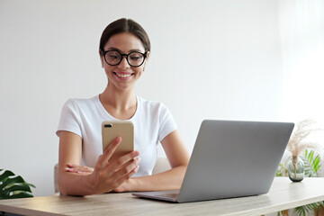 Online education concept. Young beautiful brunette woman wearing eyeglasses taking part in a group video call. Portrait of female college student studying at home. Close up, copy space, background.