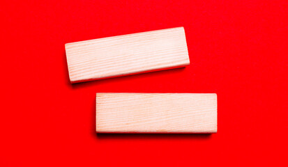On a bright red background, there are two light wooden blocks with a place to insert text.