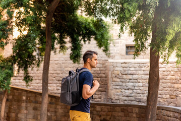 Fototapeta na wymiar Young latin tourist man visiting the city with his bag