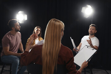 Professional actors discussing their scripts during rehearsal in theatre