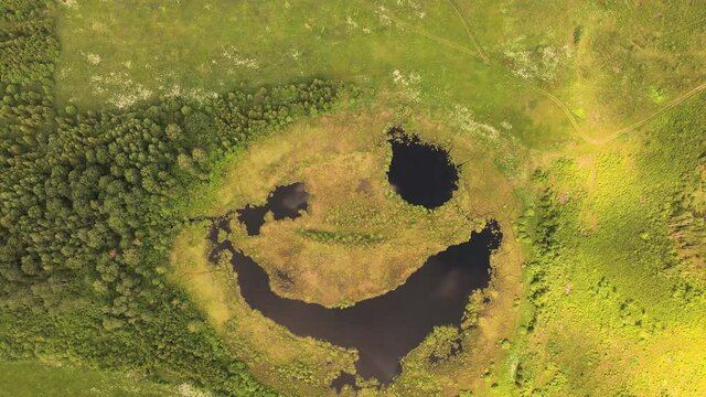 A strange natural phenomenon, the lake is a smiling face from a bird's eye view. Pond as a smiley or emoji. A smile on a natural reservoir, a view from the top, as if in a fairy tale. UHD 4K.