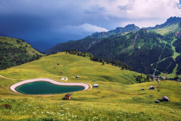 Burzowe chmury na  górami i turkusowe jezioro dolomity alpy © Sebastian