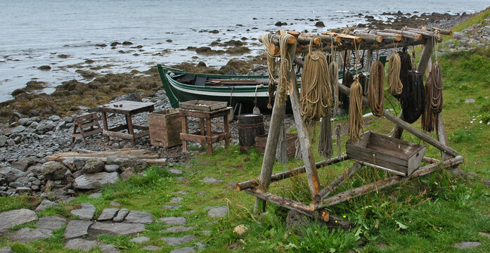 a fishing boat and a bench with a variety of nautical ropes on the fishing village of Osvor in Bolungarvik, Iceland