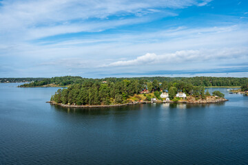 Amazing panoramic view of beautiful evergreens small islands and rocky coast of Scandinavia on summer day. Shot from cruise ship. Skyline. Forest green long coastline. Water voyage to Sweden Stockholm