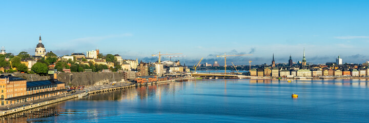 Obraz premium Panoramic beautiful View of Stockholm Swedish capital from big modern cruise ship. Ship passes through the islands of archipelago. Towers of the buildings and city dominants are visible. Water trip.