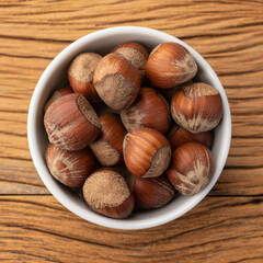 Hazelnuts in a bowl over wooden table