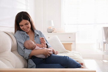 Young woman breastfeeding her little baby at home, space for text - obrazy, fototapety, plakaty