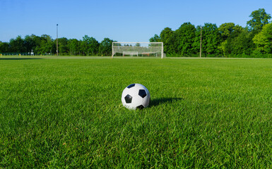 ball on the green field in village soccer stadium. ready for game in the midfield